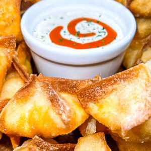 plate of buffalo chicken wonton cups with a dipping sauce