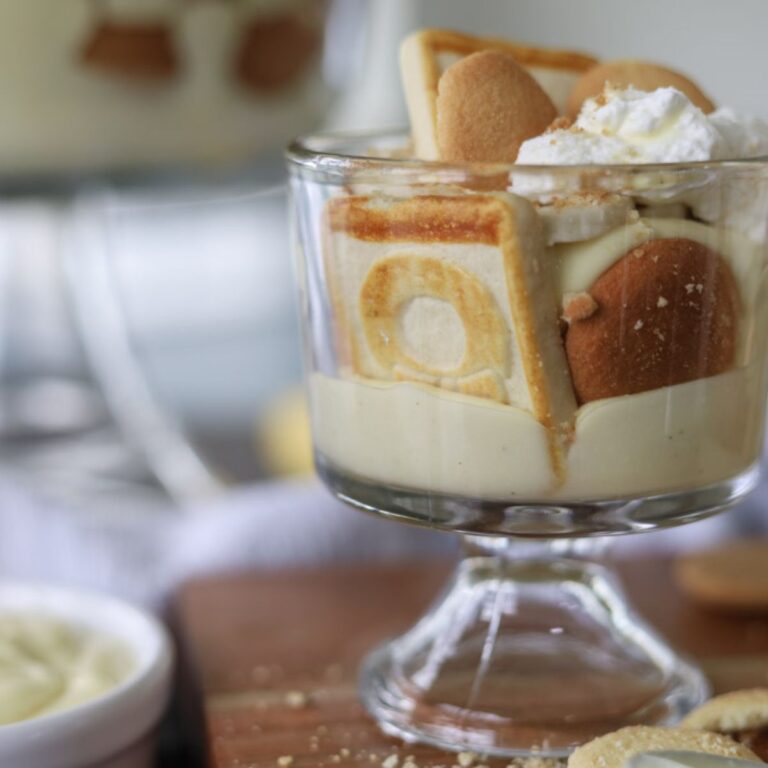 Banana Pudding in a glass topped with whipped cream on a counter