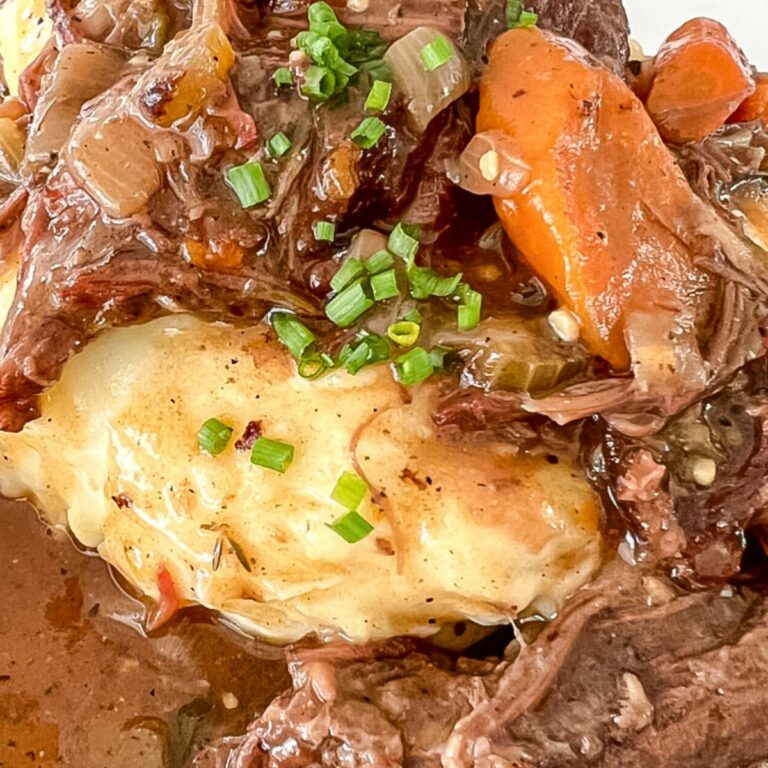 close up view of pot roast over mashed potatoes
