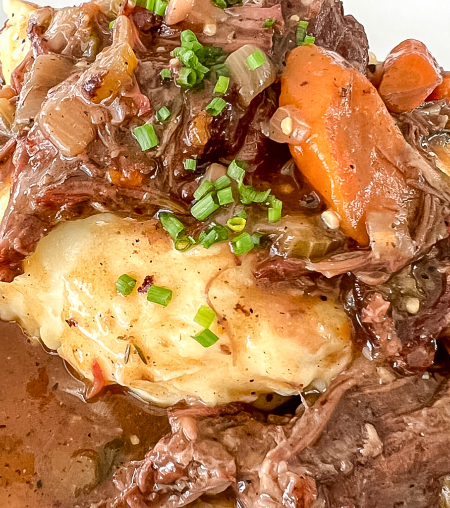 close up view of pot roast over mashed potatoes