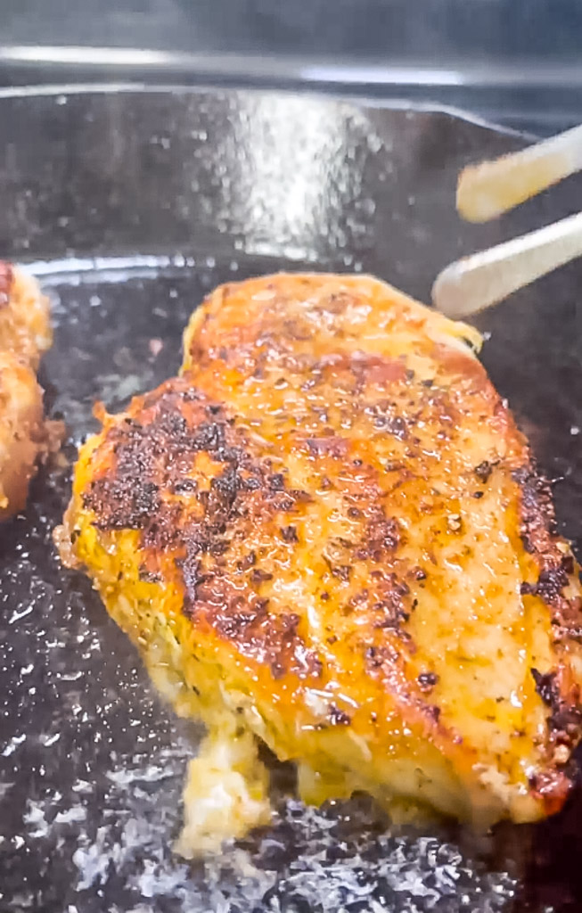 close up view of chicken breast being pan seared