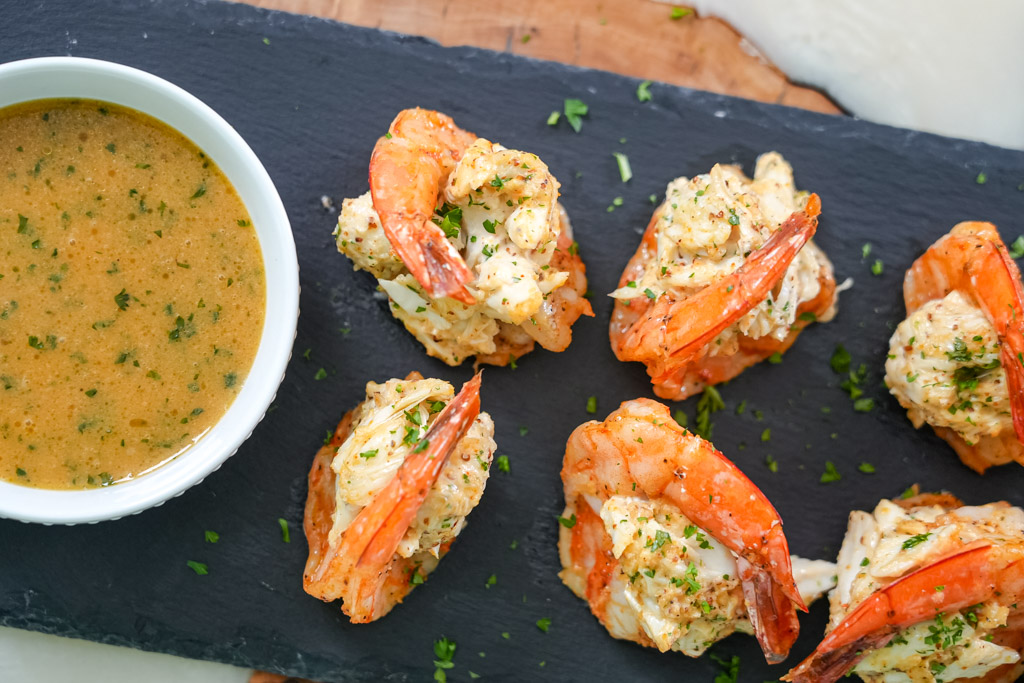crab stuffed shrimp on a platter with a side of garlic butter