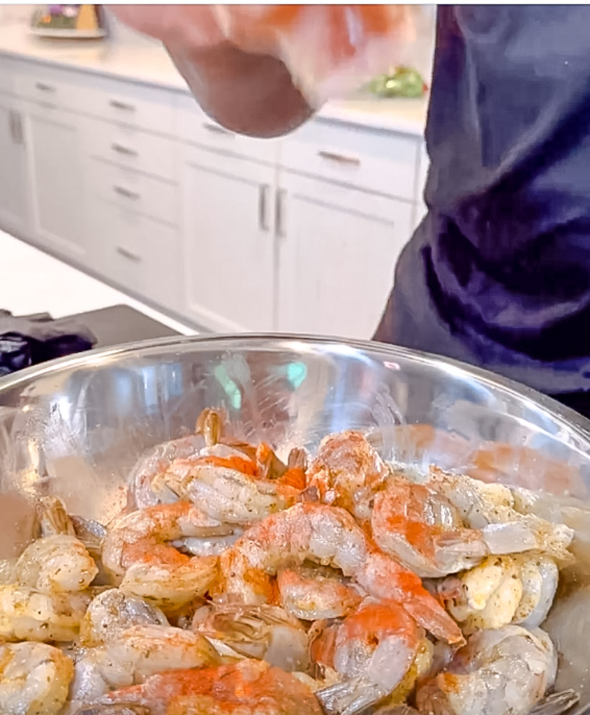 seasoning the shrimp in a bowl to make crab stuffed shrimp