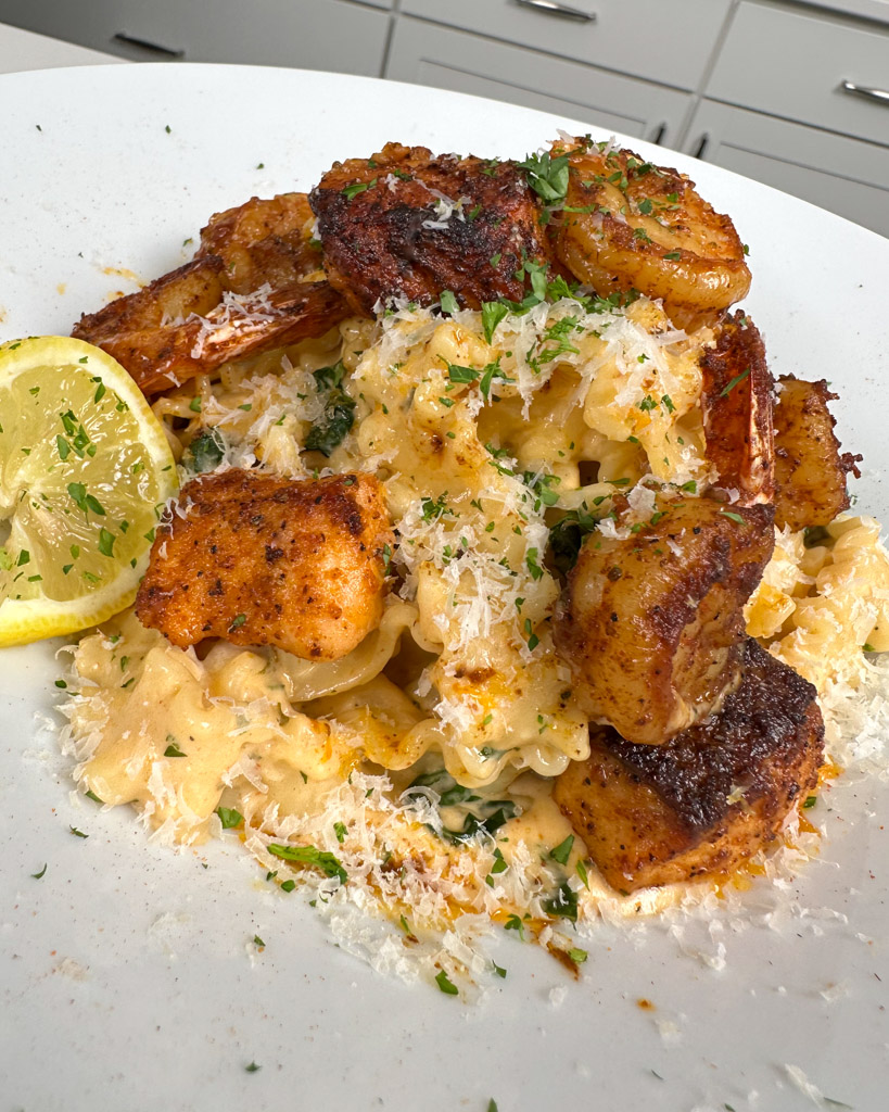 a plate of creamy cajun pasta with shrimp and salmon