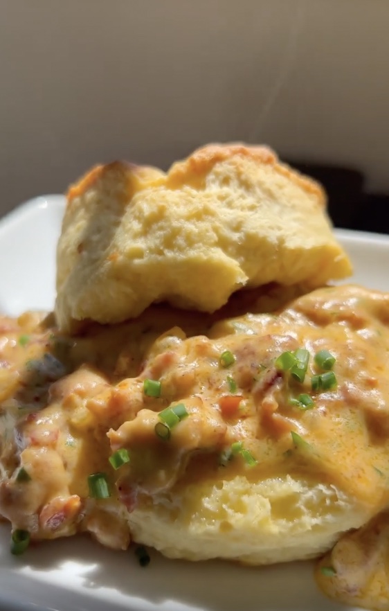 plate of homemade buttermilk biscuits with chorizo gravy on top 