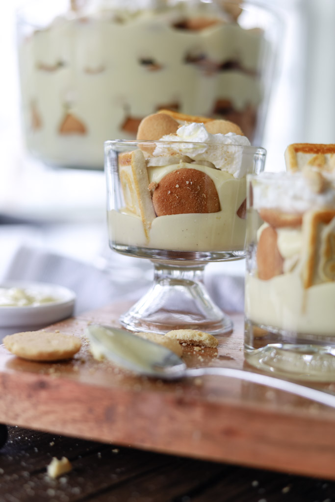 Banana Pudding in a glass topped with whipped cream on a counter