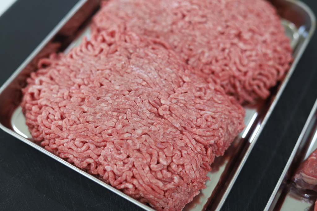 Uncooked ground beef on a baking sheet.