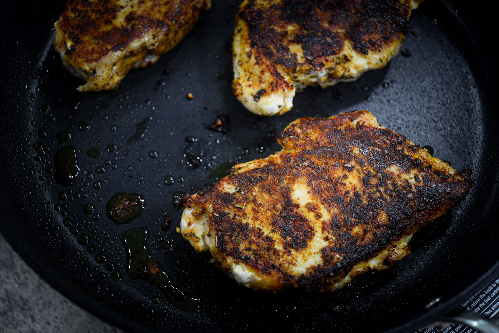 blackened chicken sitting in a pan.