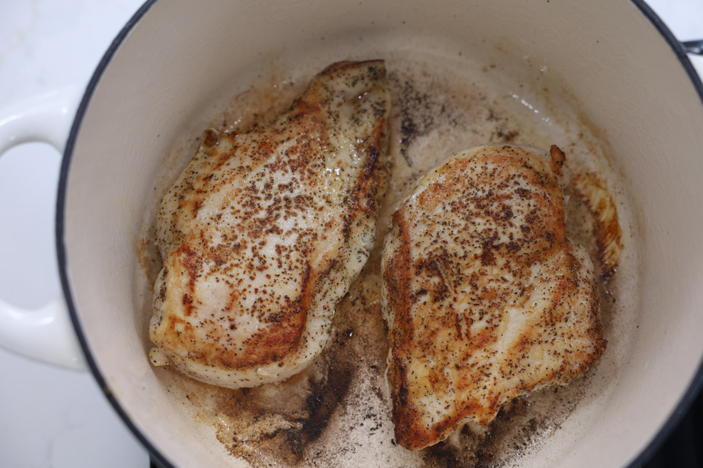 seared chicken breasts in a pot.