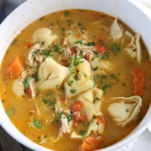 Chicken tortellini soup served in a bowl.