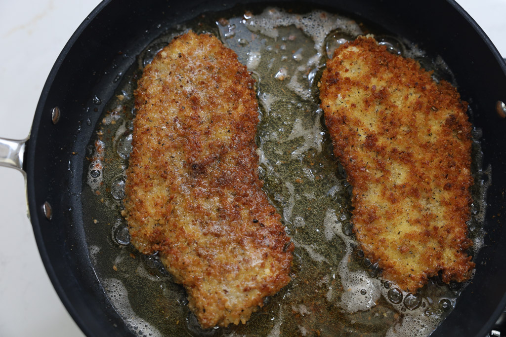 chicken breasts browned in a pan.