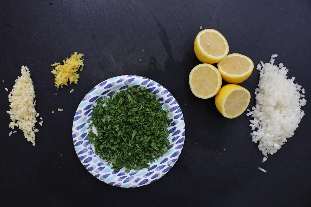parsley, lemon wedges, and lemon zest measured out for the lemon cream sauce on the counter.
