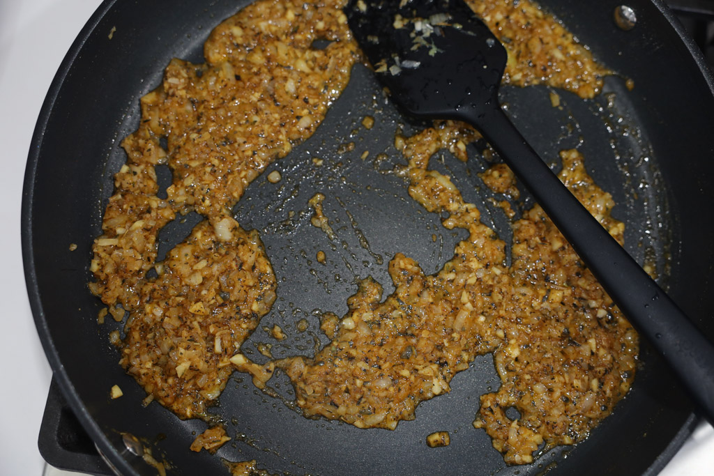 onion and garlic being browned in a pan.