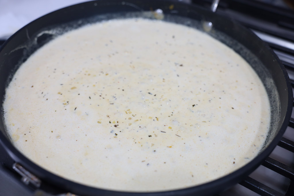 Cream being added into a pan to bring the lemon sauce together.